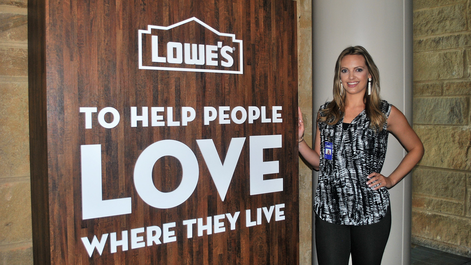 Female intern standing in front of Lowe's Companies sign.