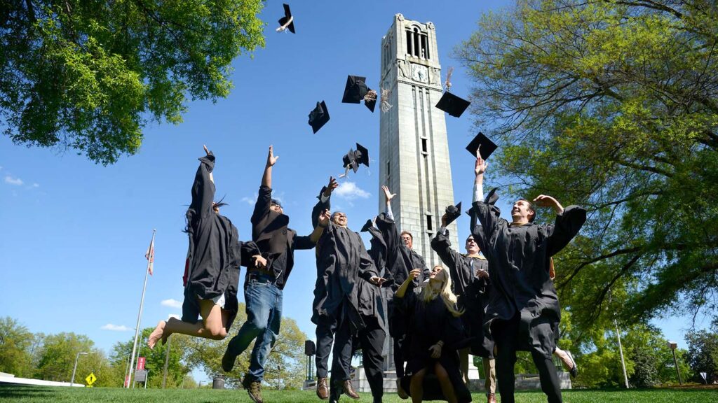 NC State MBA students celebrate by the Belltower as graduation approaches.